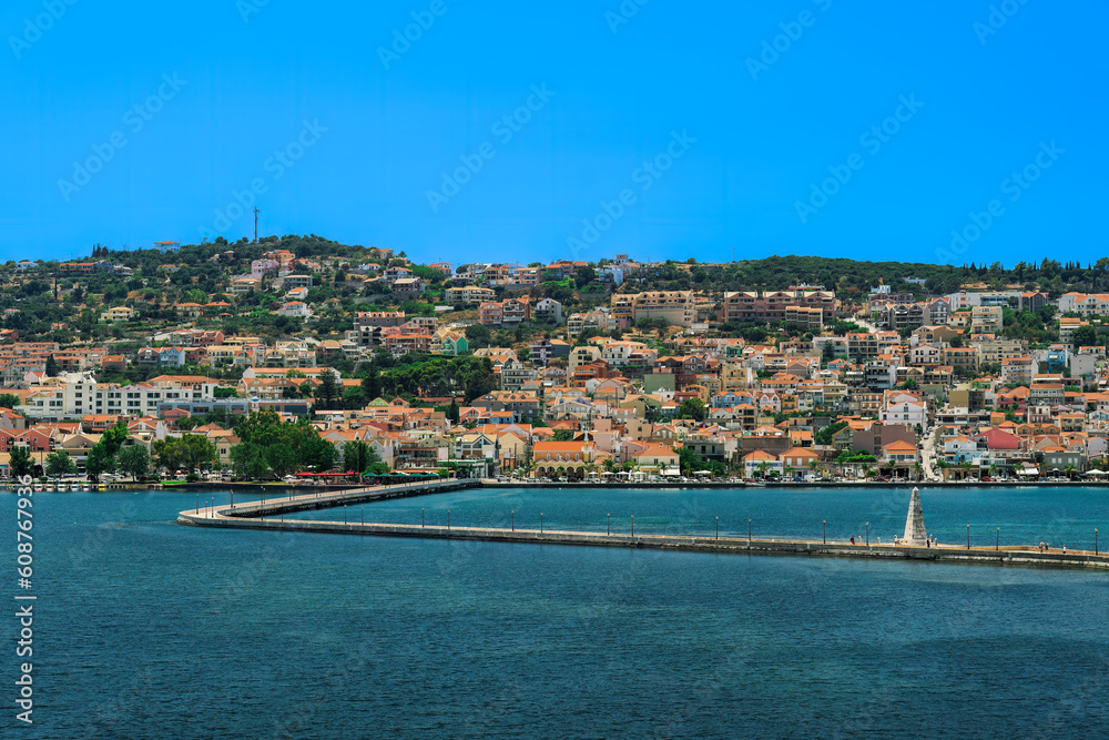 1813 stone-built water-surrounded obelisk next to De Bosset Bridge with Argostoli town panorama in the background on the Ionian Island of Cephalonia Greece.