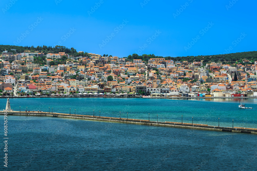 Fototapeta premium 1813 stone-built water-surrounded obelisk next to De Bosset Bridge with Argostoli town panorama in the background on the Ionian Island of Cephalonia Greece.