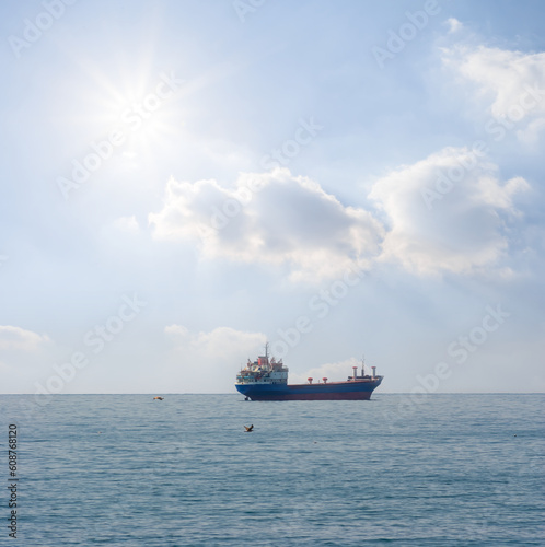 cargo ship in open sea at sunny day, marine transportation scene