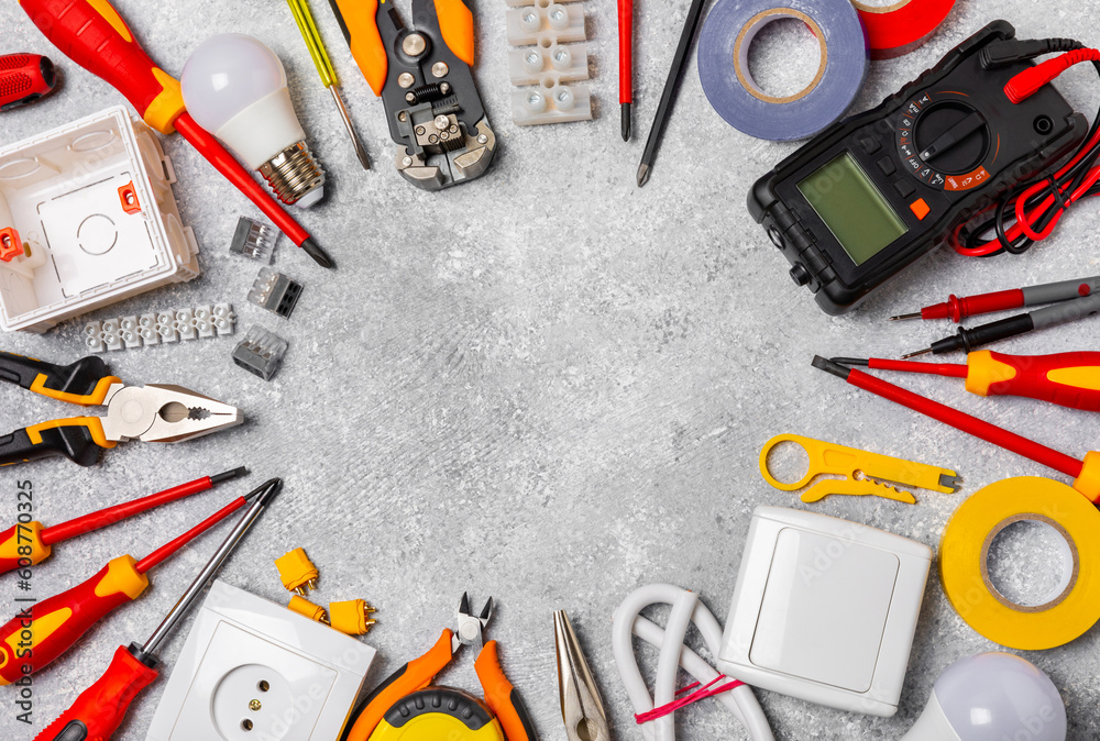 Electrician equipment on marble background with copy space.Top view.Electrician tool set.Multimeter, tester,screwdrivers,cutters,duct tape,lamps,tape measure and wires.Flet lay.