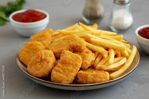 Homemade Chicken Nuggets and French Fries with Ketchup on gray background, side view. Close-up.