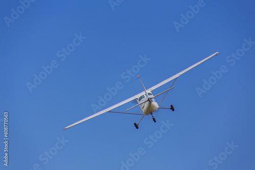 Cessna light aircraft ever built with overhead wing and single propellarin the blue sky © gannusya