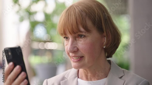Senior businesswoman having video chat in front of office