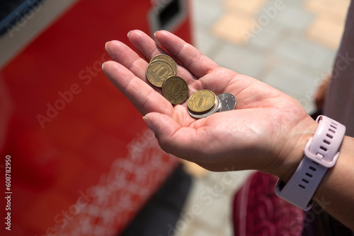 VOLGOGRAD, RUSSIA-August 17 2022: a woman holds metal coins in her palm in order to buy water at a vending machine on a hot summer day
