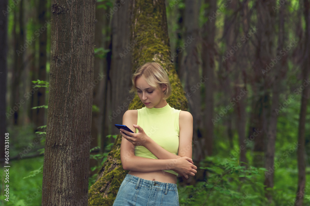 young woman with smartphone in natural forest park young woman with smartphone in natural forest park