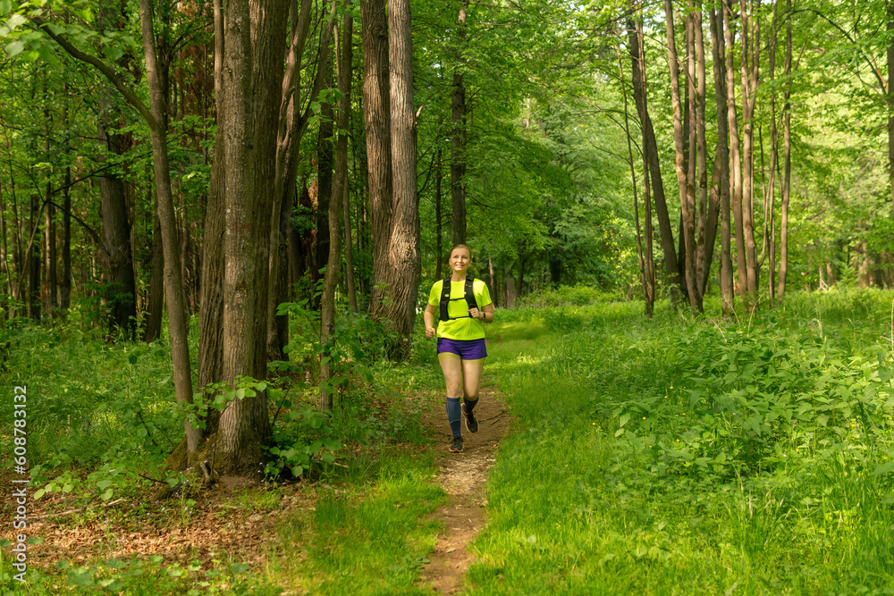 young woman jogging on a path in a natural forest park