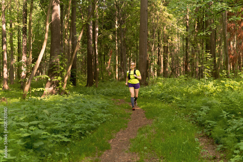 young woman jogging on a path in a natural forest park