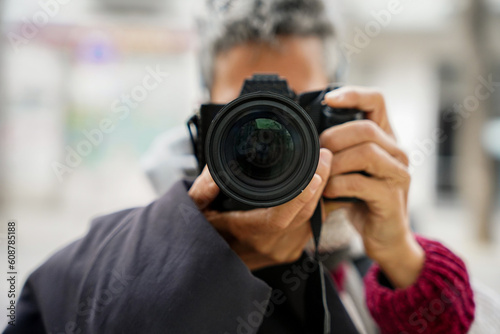 woman taking a photo with a reflex looking at camera. Photographer day