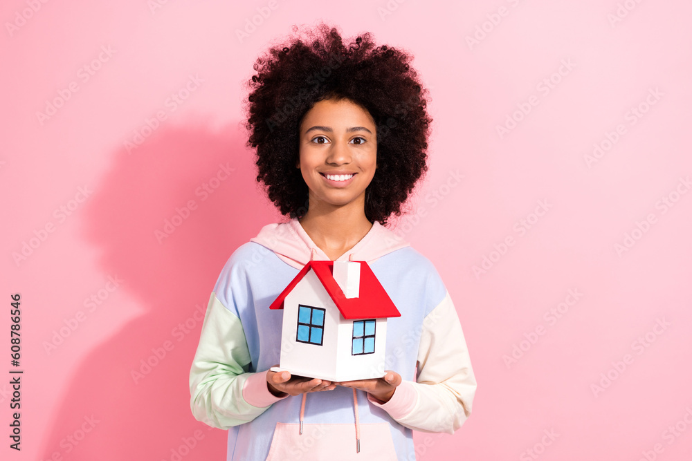 Photo of cheerful pretty little child dressed hoodie smiling holding small house isolated pink color background Photo of cheerful pretty little child dressed hoodie smiling holding small house isolated pink color background