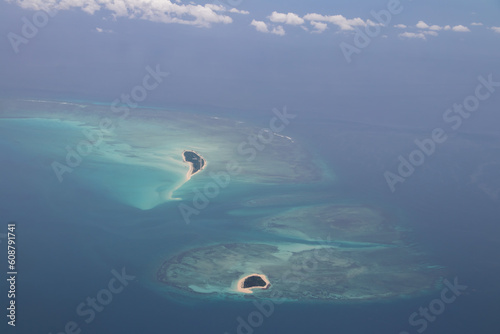 Tropical paradise beautiful island viewed from above, aerial view on crystal clear turquoise blue and green waters, amazing romantic touristic destination, shore of Mozambique