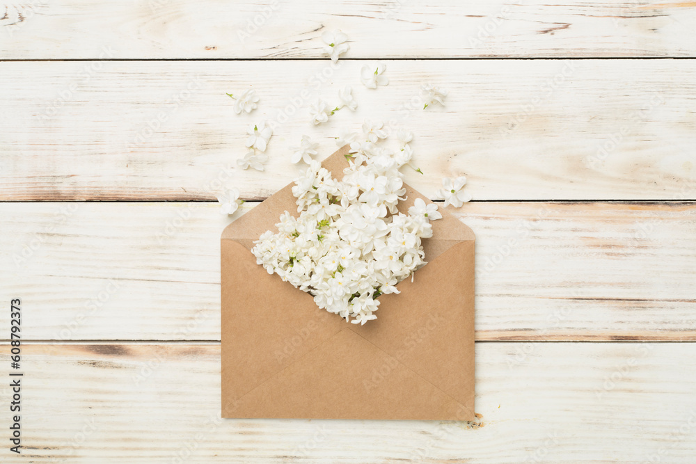 Envelop with lilac flowers on wooden background, top view Envelop with lilac flowers on wooden background, top view