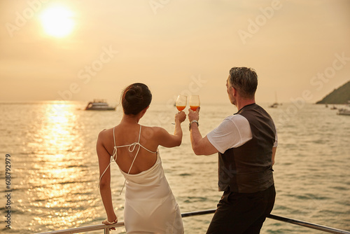 back couple drinking orange juice in luxury yacht