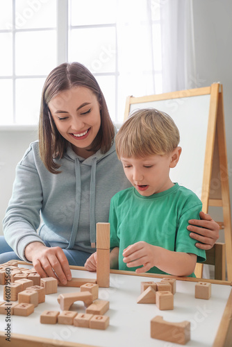 Little boy and nanny playing with cubes at home