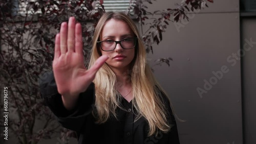 Serious girl stretch out her palm to camera says stop abortion, outdoor. Community participant anti domestic violence, racism racial discrimination. Struggle for women rights, social problems concept