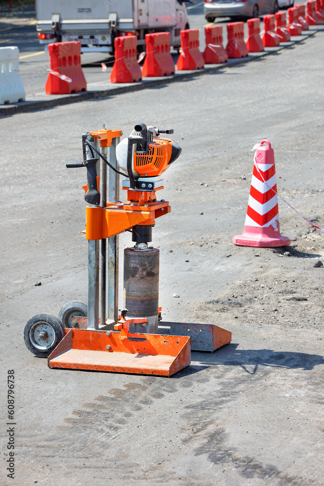 Drilling gasoline machine for cutting samples of asphalt concrete on the background of road repair.