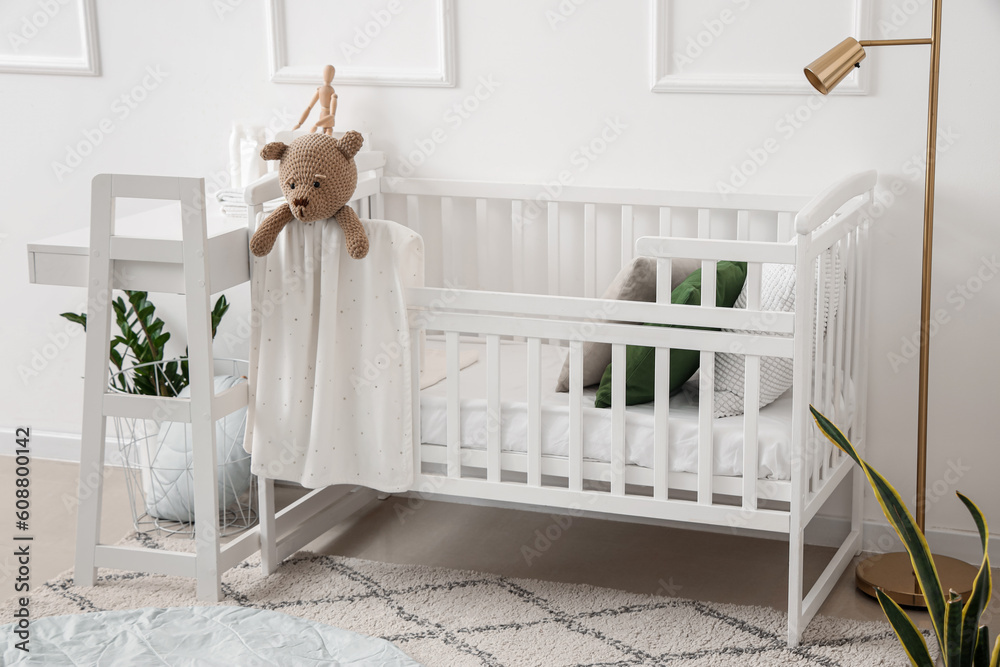 Interior of light bedroom with baby crib and changing table - obrazy, fototapety, plakaty 