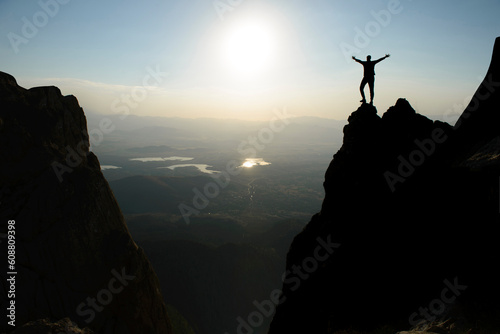 silhouette of brave and successful mountaineer on jagged cliffs © emerald_media
