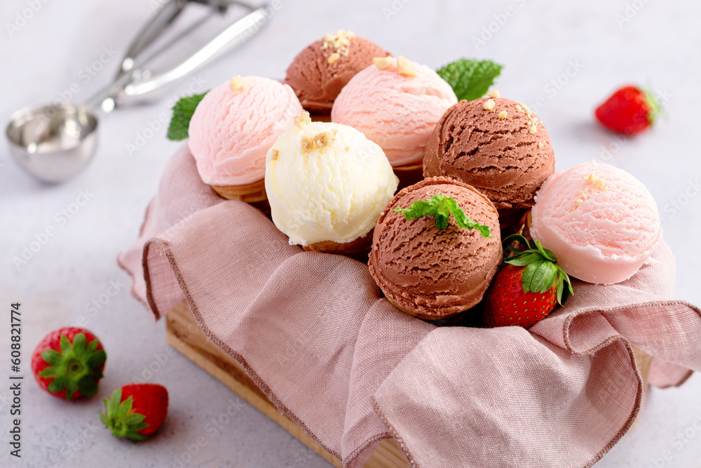 Cones with chocolate, vanilla and strawberry taste in wooden box on light gray table Cones with chocolate, vanilla and strawberry taste in wooden box on light gray table