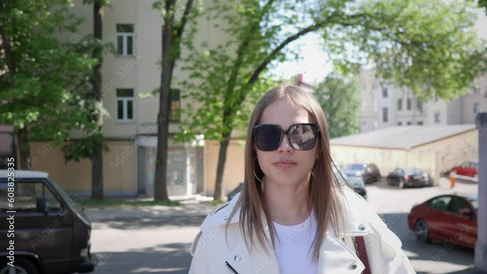 a beautiful Russian girl walks among the houses along the street of her city 4k