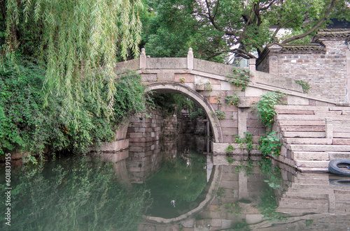 old bridge over the river with reflections and willow tree