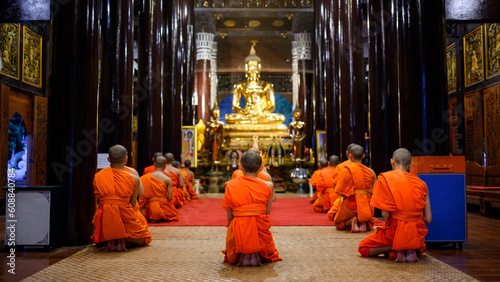 buddhist monks pray to Buddha in Thai temple at night