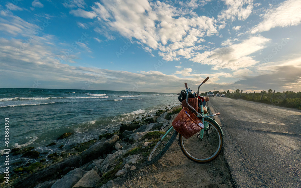 Fototapeta premium Sunset at Tulum beach with two bikes at the coastline