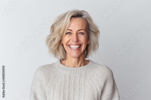 Medium shot portrait photography of a pleased woman in her 40s that is wearing a cozy sweater against a white background . Generative AI