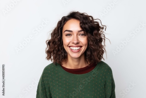 Portrait of a beautiful young woman with curly hair smiling at camera isolated on a white background © Robert MEYNER