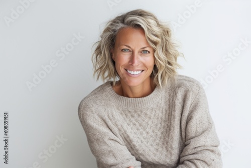 Portrait of happy woman with arms crossed against white background in studio
