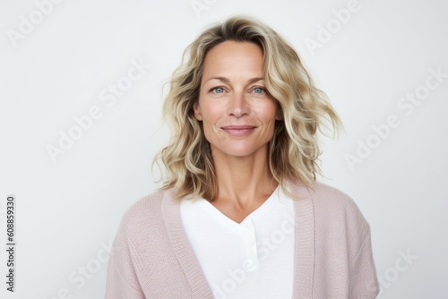 Medium shot portrait photography of a satisfied woman in her 40s that is wearing a chic cardigan against a white background . Generative AI © Anne-Marie Albrecht