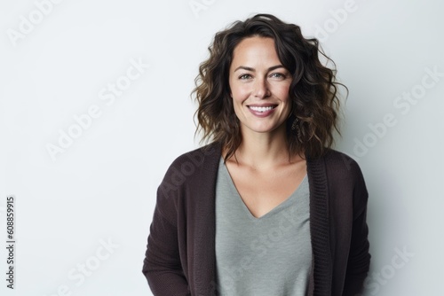 Lifestyle portrait photography of a satisfied woman in her 30s that is wearing a chic cardigan against a white background . Generative AI