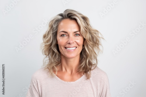 Portrait of a beautiful middle aged woman smiling at camera over white background