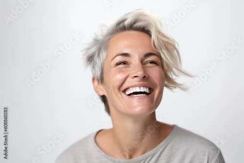 Portrait of a happy mature woman laughing and looking up on white background