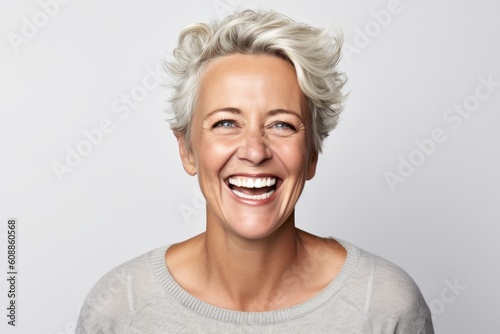 Portrait of a happy middle-aged woman laughing against white background