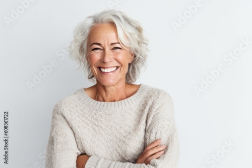 Portrait of beautiful senior woman smiling at camera while standing against white background
