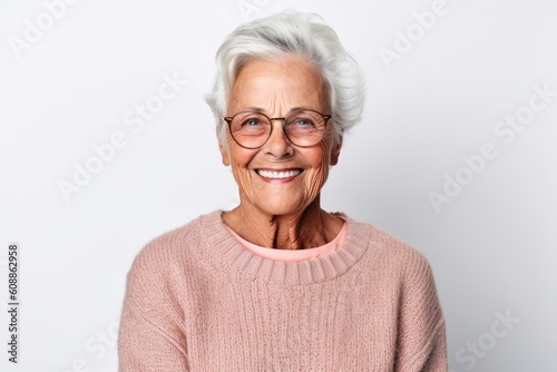 Portrait of a smiling senior woman in eyeglasses against white background