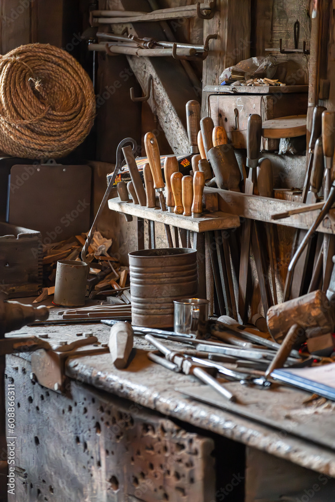 A vertical shot of an old rustic wood workshop with antique tools and equipment