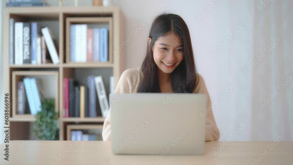 Young asian woman working at home. Female using computer laptop on desk at house Young asian woman working at home. Female using computer laptop on desk at house