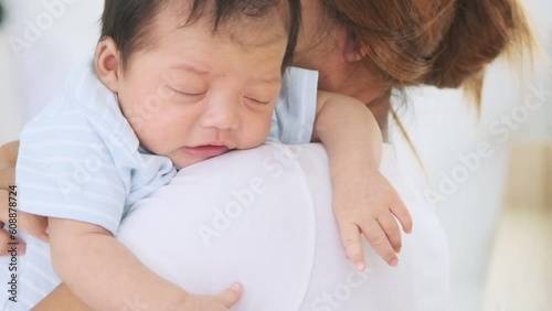 Asian cute baby fell asleep on the shoulders of mother who moved her baby to lull her daughter to sleep. photo