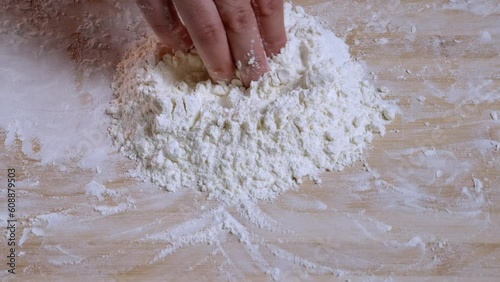 making a hole in flour to add eggs to start making dough with zooming in