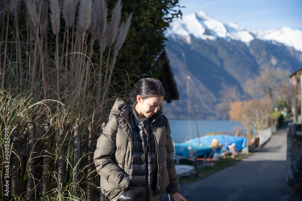 Woman enjoy view the mountain and lake in Iseltwald at Lake Brienz in Switzerland.