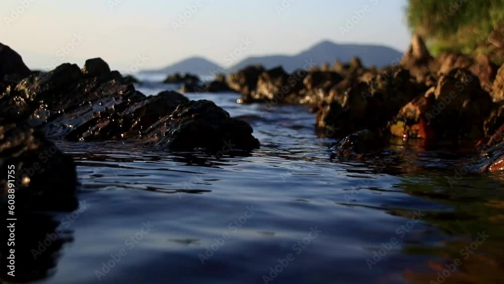 Calm and soothing ambient motion of the tide slowly rising among the rocks at summer dusk Calm and soothing ambient motion of the tide slowly rising among the rocks at summer dusk