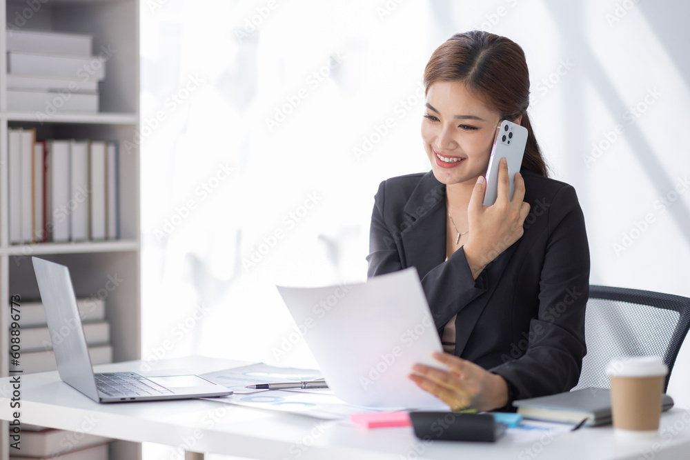 Cheerful business Asian student woman freelancer making telephone call share good news about project working in office workplace, business finance concept. Cheerful business Asian student woman freelancer making telephone call share good news about project working in office workplace, business finance concept.