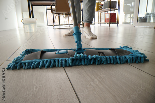 Photography Housewife cleans floor with wet fluffy mop in living room