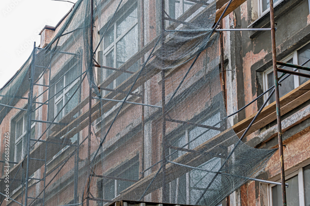 A fragment of the facade of a building under repair on a summer day A fragment of the facade of a building under repair on a summer day