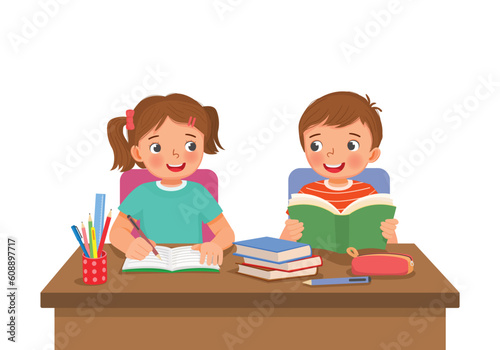 Cute school kids studying doing homework together at the desk