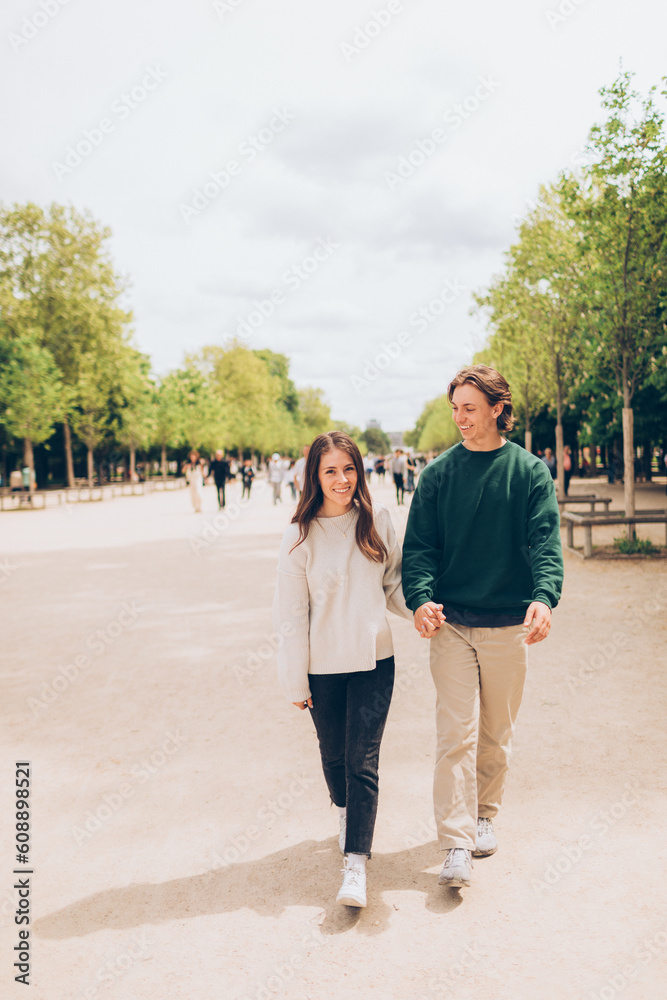 couple walking in a tree lined promenade in europe couple walking in a tree lined promenade in europe