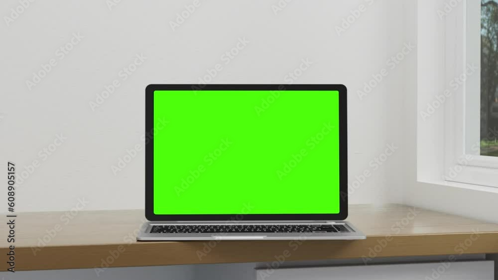 Empty green screen display Laptop turn and open in a minimal white wall Background. There was light from the windows at different times. 3D rendering Empty green screen display Laptop turn and open in a minimal white wall Background. There was light from the windows at different times. 3D rendering