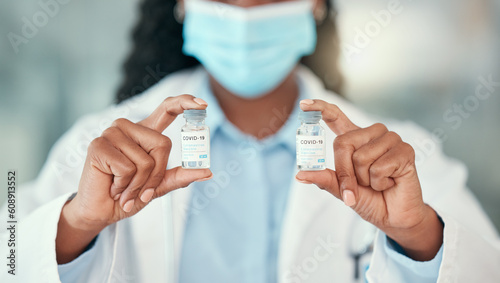 Doctor hands, covid and black woman with vaccine vials for virus or corona. Bottles, medical professional and person with vaccination mask, medicine or pharmaceutical drugs for healthcare at hospital
