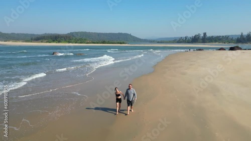 couole walking on beach aerial landscape of coastline and a beach seascape view drone Goa photo